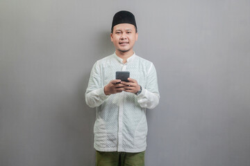 Happy asian muslim man using smart phone cellphone for calls