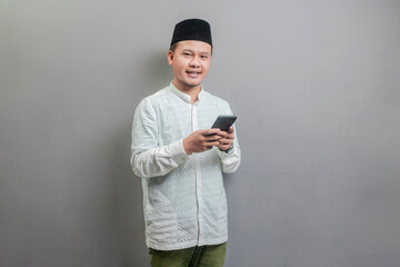 Happy asian muslim man using smart phone cellphone for calls