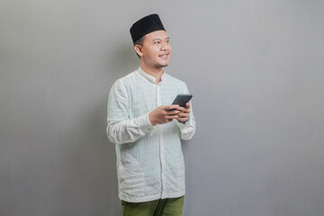 Happy asian muslim man using smart phone cellphone for calls