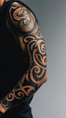 The bold presence of a Maori-inspired sleeve tattoo on a man's arm, its intricate swirls and tribal motifs wrapping around his bicep against a clean, solid backdrop.