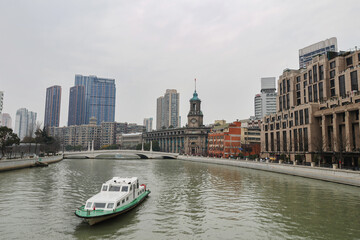 River scenery with boats running in the background and many buildings.