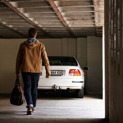 Parking, garage and man travel in car for morning commute or transportation for vacation on holiday. Luggage, bag and person with motor journey to work or walking in underground lot to parked vehicle © peopleimages.com