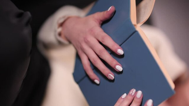 Female hands holding a book and leafing through the page