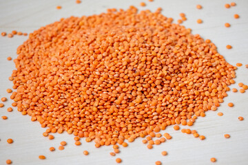 Pile of Red lentils or Masoor Dal isolated over wooden background. Incorporating red lentils into your diet can help you easily meet fiber and protein needs.