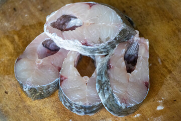 Sliced Rui fish placed on a wooden background. Chopped raw fish for cooking. 