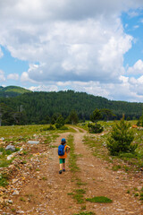 Obraz premium Traveling child. a tourist with a backpack walks along a mountain road. hiking and active healthy lifestyle.