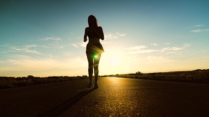 silhouette sports girl running along road sunset, attractive asian woman, runner running fitness,...