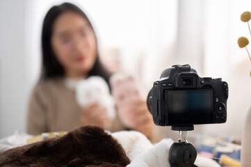 A close-up image of a camera recording a female content creator influencer at home.