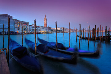 Scenic Venice sunset on the Grand Canal with a San Marco view and Gondolas in the foreground.