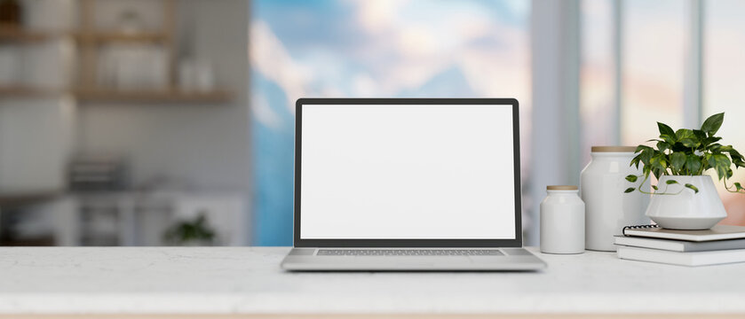 A close-up image of a white-screen laptop computer mockup on a white desk in a modern white room.