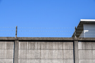 Fototapeta na wymiar 鉄条網が張られたコンクリートの壁