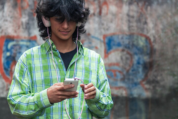 young man with headphones and phone on the street