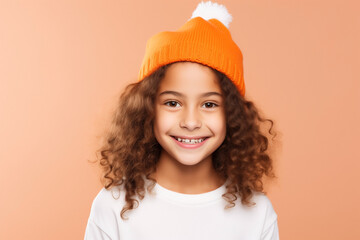 girl in orange knitted hat with white baby on pastel background