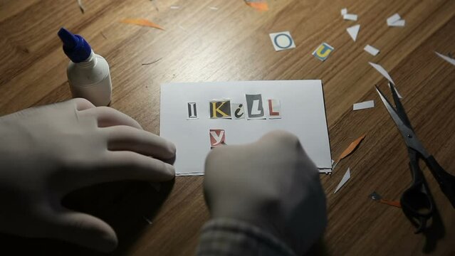 An unknown man wearing gloves pastes paper letters into an anonymous letter. A letter containing threats and violence.