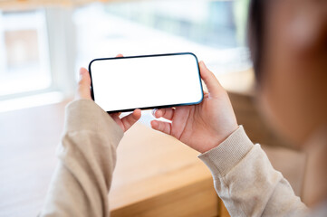 A white-screen smartphone mockup in a horizontal position in a woman's hand.