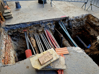 laying high voltage cables to ground. Excavation meter deep in the ground, black plastic coated...