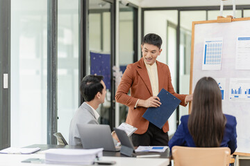 Asian business team having financial meeting with documents in office, having casual conversation in conference room. Business and office ideas Business team with laptop computers and documents