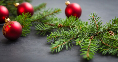 Festive Christmas tree branch adorned with ornaments, set on a dark table, signaling the holiday season.