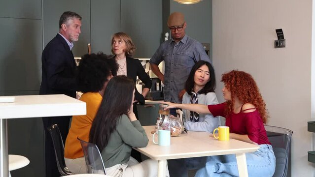group of people talking while having breakfast in the kitchen
