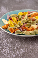 Colorful pasta background. Top view of five colors pasta shells .Heap of colorful spiral pasta,macaroni texture.