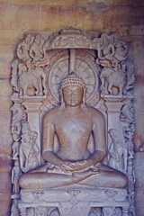 A finely detailed stone sculpture of a Jain Tirthankara ADINATH, with a serene expression, surrounded by ornate carvings