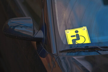 Disabled car sign on windscreen. Sign of disabled car, designated for accessible parking spaces to provide convenience and accessibility for vehicles with permit holders and disabled individuals