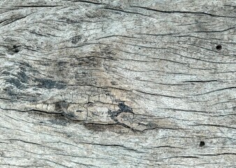 Closeup shot of a grayish wood surface with cracks and lines