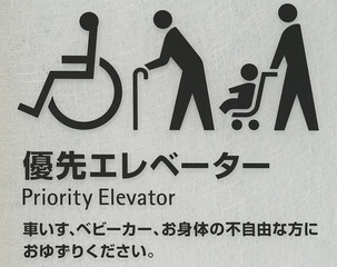 Information sign with priority elevator letters and pictograms in elevator halls in Japan
