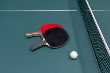 Table tennis ball and two rackets on the table - stock photo