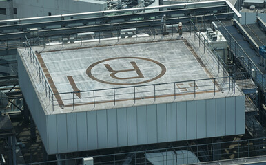 The letter R for emergency rescue space in a helicopter written on the roof of a high-rise building