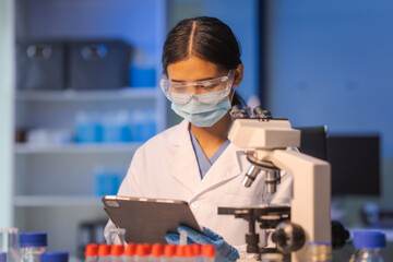 Close up female scientist in white lab coat working in biotechnological laboratory, using...