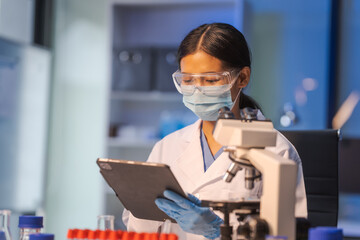 Close up female scientist in white lab coat working in biotechnological laboratory, using...