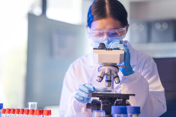 Close up female scientist in white lab coat working in biotechnological laboratory, using...