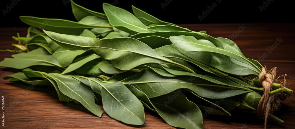 Wall mural A close-up of lush green leaves displayed on a wooden table