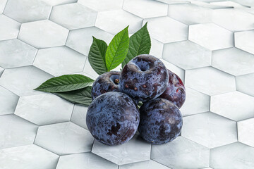 Raw purple plums heap with leaves