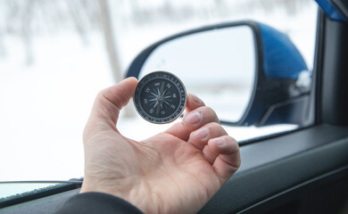 Man sitting in a car showing compass.