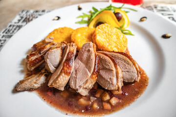 Duck breast sous vide in sauce with apple, fried potato medallions on white plate. - 763864790