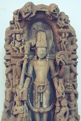 Obraz premium A finely detailed stone sculpture of a Jain Tirthankara Parshvanatha, with a serene expression, surrounded by ornate carvings