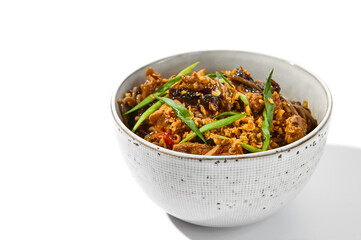Asian fried buckwheat noodles with beef and vegetables isolated on white background. Japanese fried noodles teriyaki in ceramic bowl. Fried on wok soba with beef in minimal style. Wok menu.
