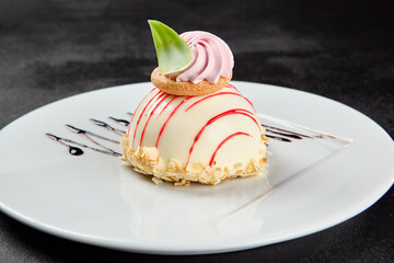 Mousse cake with berries taste and meringue on white plate on dark background. Berry cheesecake in glazed topped. Mousse cake in minimal style. Confectionery menu. Light mousse dessert.