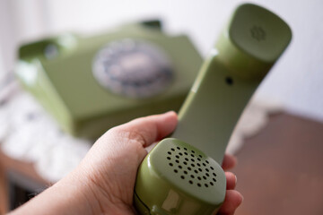 female hand holding handset of green phone, Rotary Telephone with Disc Dial, Well-Maintained...