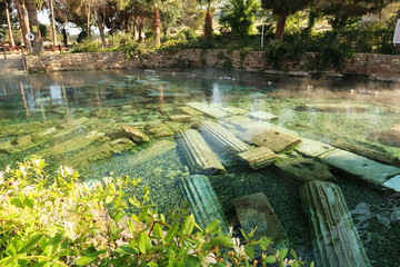 The picturesque Cleopatra Pool, hot spring with submerged roman columns inside in the early...