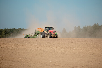 The farmer plows the field with a tractor with a plow - technicians in helping farmers - a powerful...