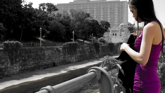 Attractive petite girl in dress puts on long scarf, being mysterious and unattainable. Slowmotion medium shot.