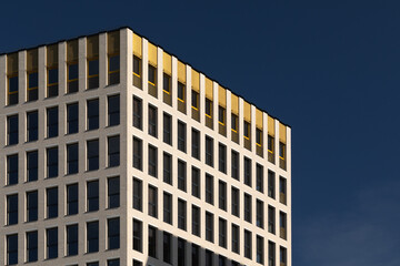 Fototapeta premium Facade of modern building. Bright sunlight and blue sky background.