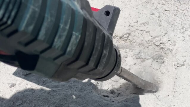 Close-up of heavy duty pneumatic hammer tool breaking reinforced concrete. Demolition of building interior. Under construction. 4K resolution industrial background with copy space and sound. Repair.