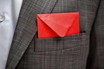 red envelope tucked in a business suit pocket - obrazy, fototapety, plakaty