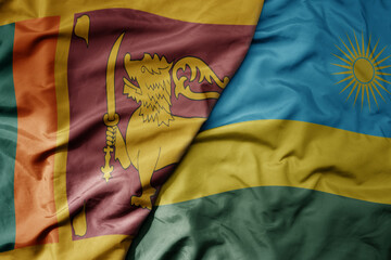 big waving national colorful flag of rwanda and national flag of sri lanka .