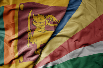 big waving national colorful flag of seychelles and national flag of sri lanka .