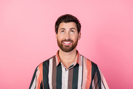 Photo of creative minded person beaming smile look up above empty space isolated on pink color background